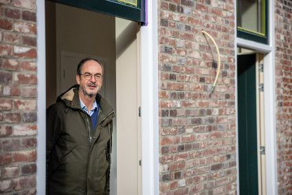 Rob Tebbe, directeur van NV Stadsherstel Breda in deuropening van gerestaureerd armenhuisje
