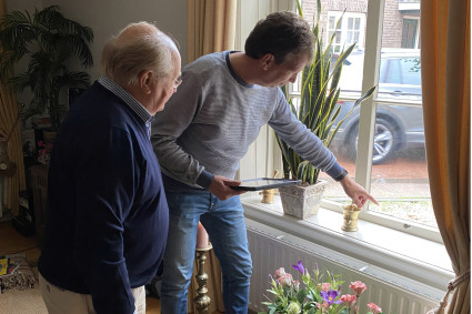 Twee personen bekijken glas in venster